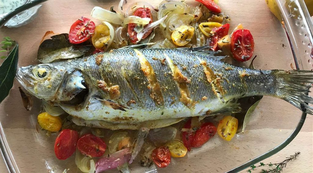 Pesce al forno con salsa tahini e aromi mediterranei